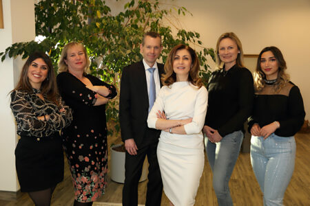 Teamfoto es sind 5 Frauen und ein Mann zusehen, alle stehen in der Anwaltszkanzlei